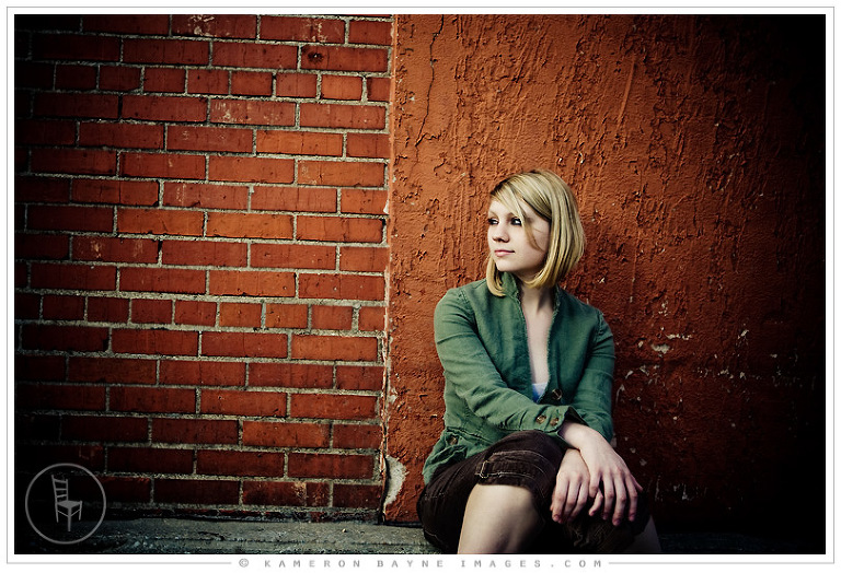 fashion and editorial portrait of high school senior against red wall